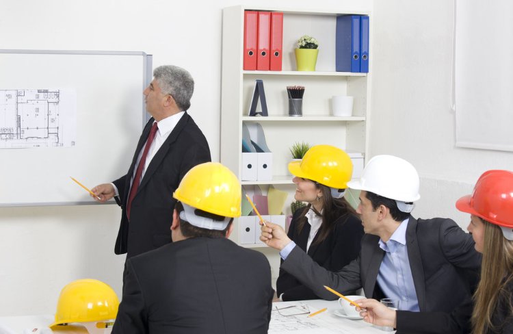 Cztery osoby w kaskach i prowadzący szkolenie