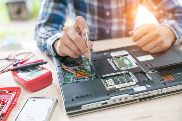 Mężczyzna naprawia laptopa
