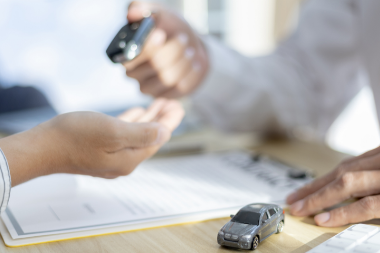 Jedna osoba wręcza drugiej pilota do samochodu