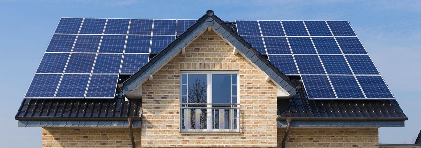 panele fotowoltaiczne zainstalowane na dachu domu z jasnej cegły