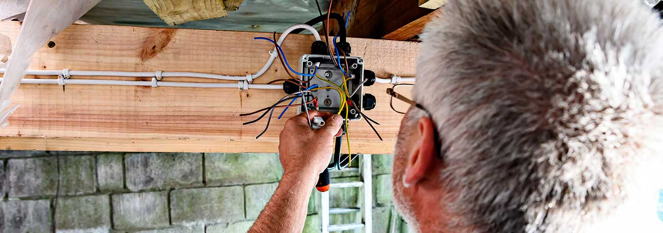 elektryk rozprowadza instalację elektryczną w garażu